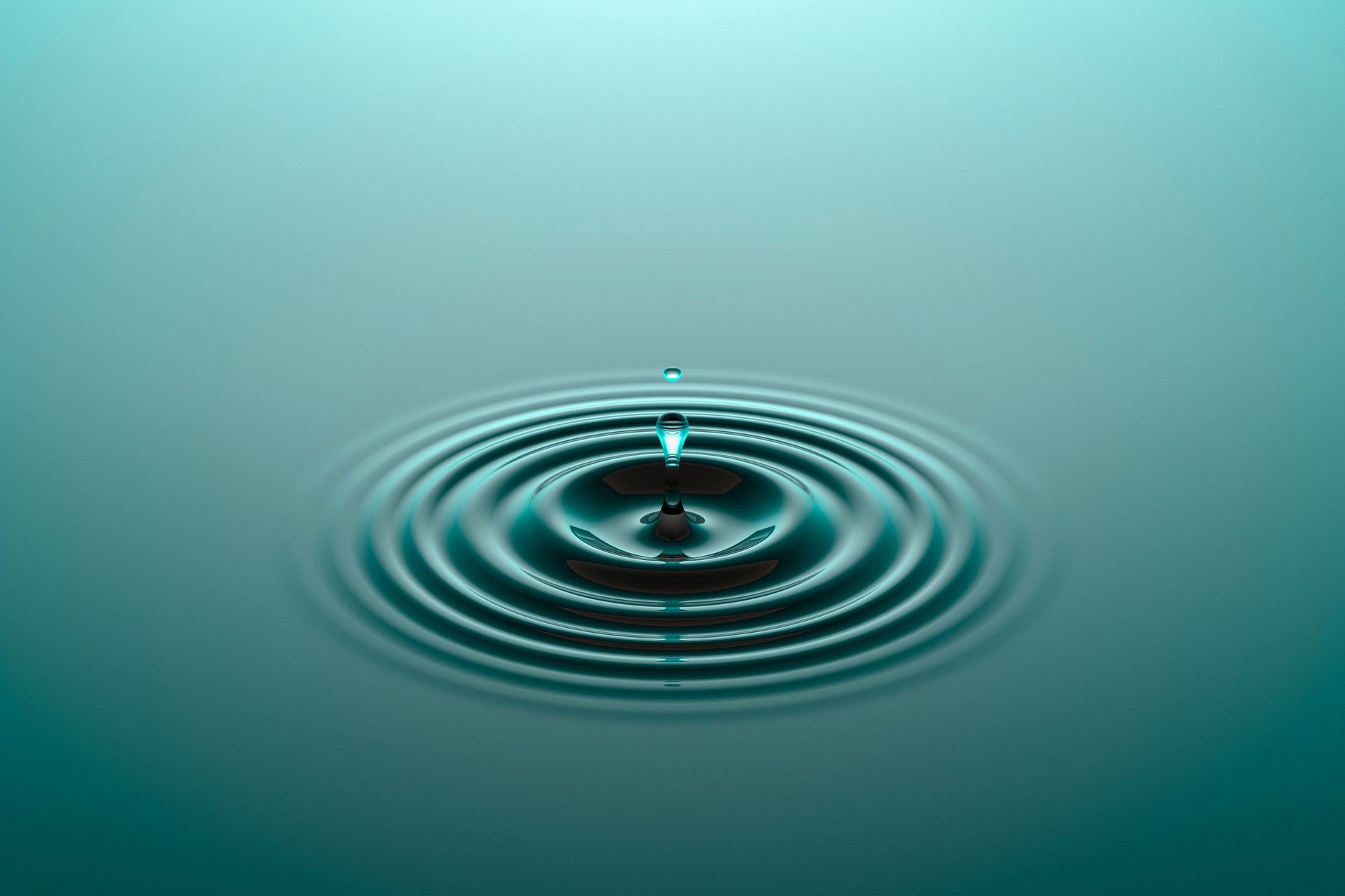 Water drop falling into water surface with ripples